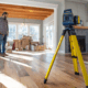 Laser level equipment measuring floor slope during professional foundation inspection in Rhode Island home